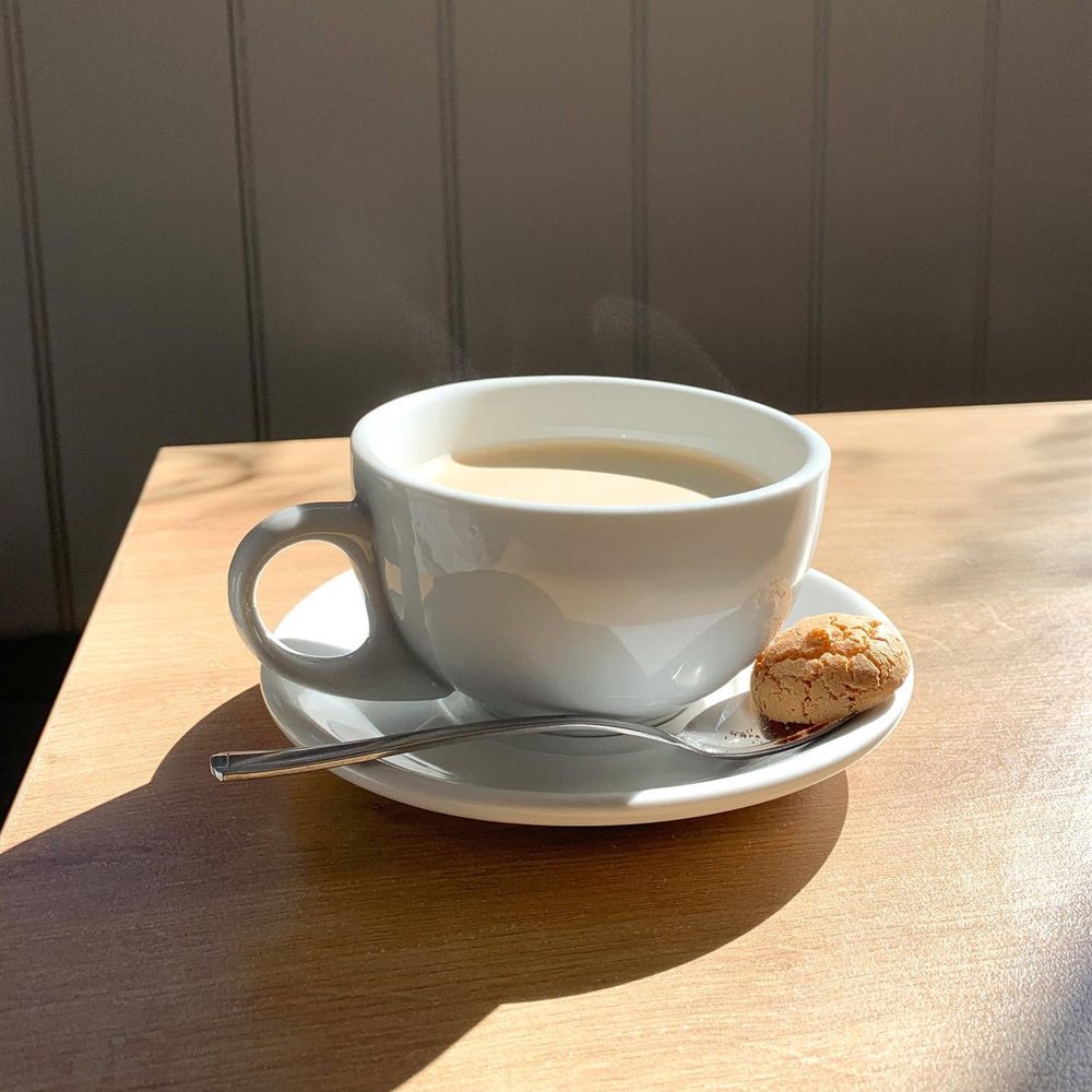 A cup of coffee on a sunny table